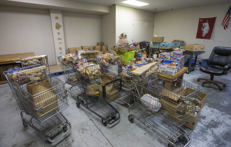 Shopping carts filled with food at the Helping Hands Inc. Thrift Store in Bentonville. (NWA Democrat-Gazette/Ben Goff)