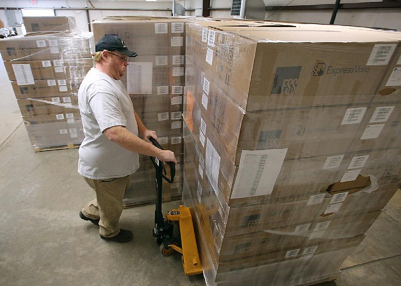 Bart Moreland, an equipment specialist for Pulaski County unloads new voting equipment on Friday, April 10, 2020, at the Pulaski County warehouse in Little Rock. The Pulaski County Election Commission 300 ExpressPoll electronic pollbooks, 140 DS200 ballot scanners and 265 ExpressVote ballot marking devices which will make their debut on the Nov. 3, general election.
(Arkansas Democrat-Gazette/Thomas Metthe)