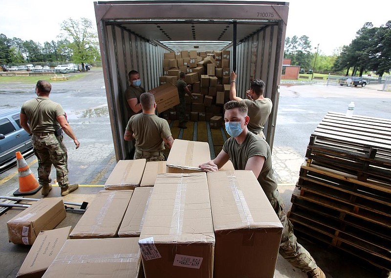 Arkansas National Guardsmen unload a shipment of personal protective equipment at the Federal Surplus Warehouse on Sunday, April 12, 2020. 
(Arkansas Democrat-Gazette/Thomas Metthe)