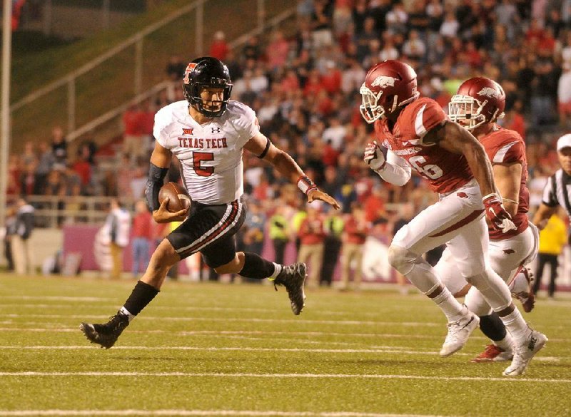 Texas Tech quarterback Patrick Mahomes (left) scrambles away from Arkansas defender Rohan Gaines during the Red Raiders’ victory over the Razorbacks at Fayetteville on Sept. 19, 2015. This season, Mahomes led the Kansas City Chiefs to a Super Bowl championship. (Democrat-Gazette file photo) 
