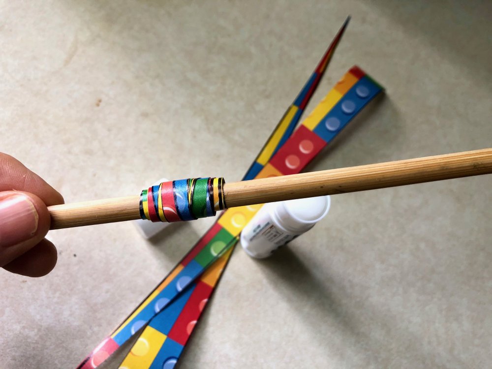 Long thin paper triangles wrapped around a chopstick and glued become paper beads in this craft project. (Arkansas Democrat-Gazette/Celia Storey)
