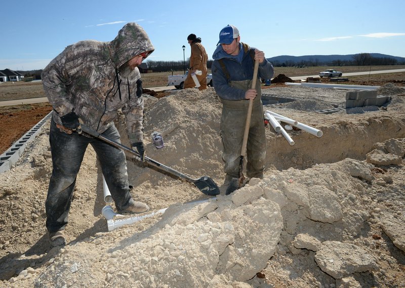 Vance King (from left), a journeyman plumber, works Feb. 27 alongside Hunter Young, an apprentice plumber, as master plumber Jay Shackleford walks through the site as they cover up a pipe at a construction site inside The Farmington Heights development in Farmington. Go to nwaonline.com/200413Daily/ for today's photo gallery. (NWA Democrat-Gazette/Andy Shupe)