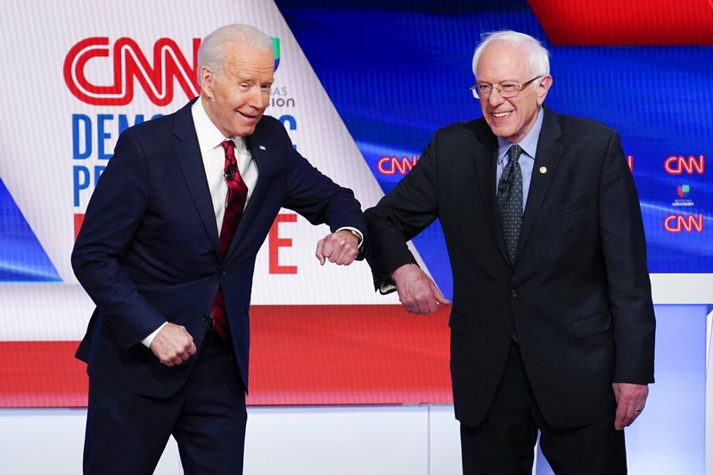 Former Vice President Joe Biden, left, and Sen. Bernie Sanders, I-Vt., right, greet each other before they participate in a Democratic presidential primary debate at CNN Studios in Washington, Sunday, March 15, 2020. 