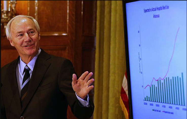 Gov. Asa Hutchinson uses a chart to show actual hospitalized patients and the projected number during his daily briefing about the coronavirus Friday at the state Capitol. More photos at arkansasonline.com/411covid/. (Arkansas Democrat-Gazette/Thomas Metthe)