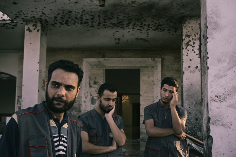 Haytham Garabiya, left, photographed in October, stands with other paramedics near the entrance of the field hospital of Siedi Salim in the aftermath of a drone strike. He has been forced to move his hospital to a new location as it has continued to be hit by drones as Libya's war escalates. MUST CREDIT: Photo for The Washington Post by Lorenzo Tugnoli