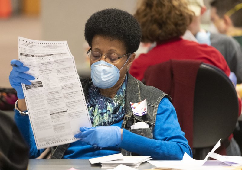 City of Milwaukee Election Commission workers process absentee ballots Tuesday, April 7, 2020 in downtown Milwaukee, Wis. Despite federal health recommendations, thousands of Wisconsin voters waited hours in long lines outside overcrowded polling stations on Tuesday so they could participate in a presidential primary election that tested the limits of electoral politics in the midst of a pandemic. (Mark Hoffman/Milwaukee Journal-Sentinel via AP)