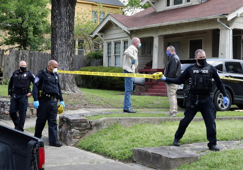 HSPD officers place crime scene tape around 307 Oakcliff Street Tuesday. Photo by Richard Rasmussen of The Sentinel-Record