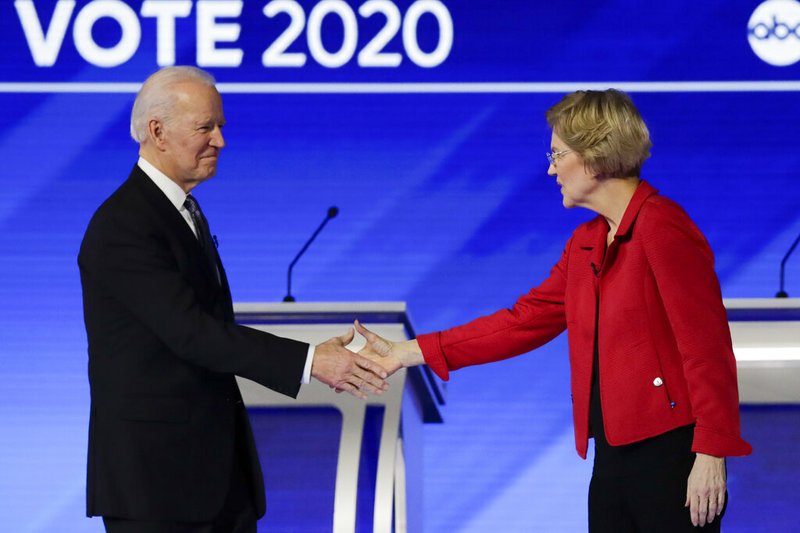 FILE- In this Feb. 7, 2020 file photo, Democratic presidential candidates former Vice President Joe Biden, and Sen. Elizabeth Warren, D-Mass., shake hands on stage before the start of a Democratic presidential primary debate hosted by ABC News, Apple News, and WMUR-TV at Saint Anselm College in Manchester, N.H. Warren has endorsed Joe Biden, becoming the last of the former vice president’s major Democratic presidential rivals to formally back him.(AP Photo/Charles Krupa)