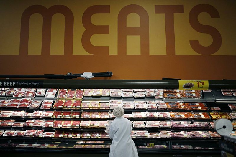 An employee restocks shelves with pork in the meat section in a Kroger supermarket in Louisville, Ky., in this file photo. Food industry leaders say shortages of some products could increase, but insist it will be more of an inconvenience than a problem. (Bloomberg/Luke Sharrett) 