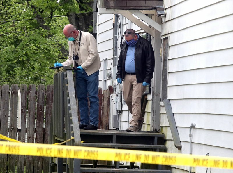 Garland County Coroner Stuart Smedley, left, and Hot Springs Police Sgt. Mike Hall work the scene of a homicide Tuesday morning at 307 Oakcliff St. A local man, Terry Eugene Hughes, 55, has been charged with first-degree murder for the death of Joshua David Buck, 43, who lived at the Oakcliff Street apartment. - Photo by Richard Rasmussen of The Sentinel-Record