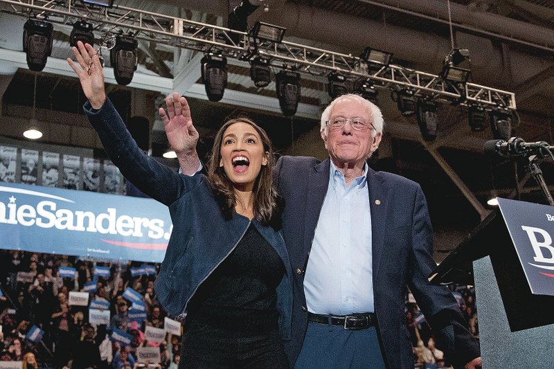 Former Democratic presidential candidate Sen. Bernie Sanders, I-Vt., accompanied by Rep. Alexandria Ocasio-Cortez, D-N.Y., (left), takes the stage Feb. 10 at campaign stop at the Whittemore Center Arena at the University of New Hampshire in Durham, N.H. (File Photo/AP/Andrew Harnik)