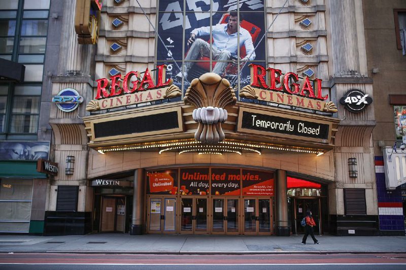 In this March 21 file photo, a pedestrian wearing a protective face mask due to covid-19 concerns walks by a shuttered movie theater in New York. Movie theaters may be closed, but friends are still finding ways to watch together while staying apart thanks to applications like Netflix Party.
(AP Photo/John Minchillo, File)
