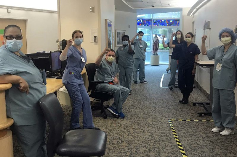 Nurses at Providence Saint John’s Health Center in Santa Monica, Calif., raise their fists in solidarity last week after telling managers they won’t care for covid-19 patients without N95 respirator masks to protect themselves.
(AP/Lizabeth Baker Wade)