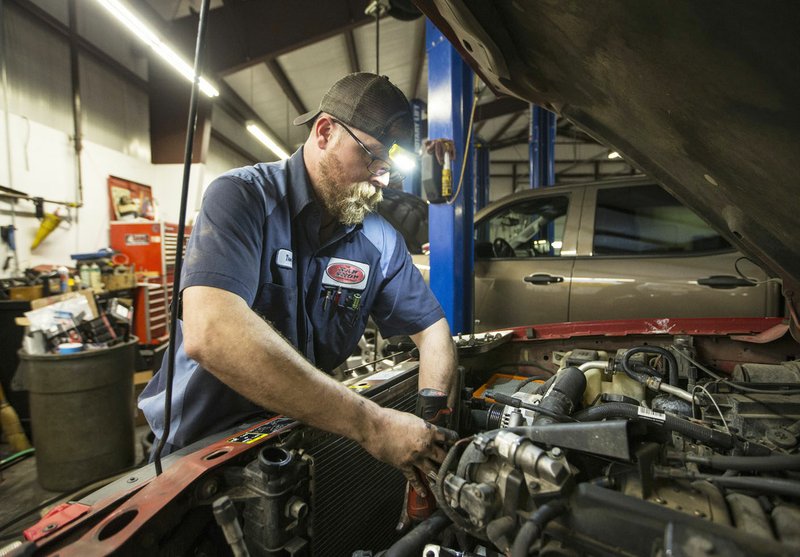 Truen Taylor works Monday on a customer's truck at The KAR Shop in Rogers. Go to nwaonline.com/photos to see more photos. (NWA Democrat-Gazette/Ben Goff)