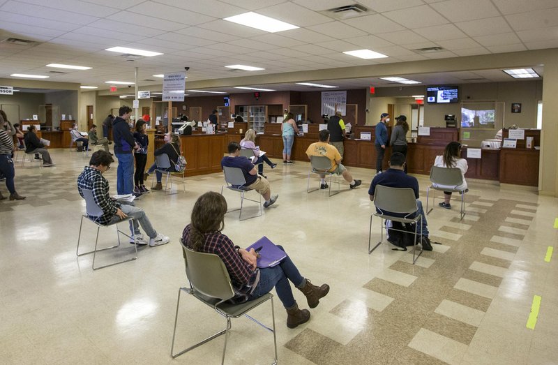 Customers sit a safe distance apart Thursday while waiting for their number to be called at the state revenue office in Bentonville. Go to nwaonline.com/photos to see more photos. (NWA Democrat-Gazette/Ben Goff)