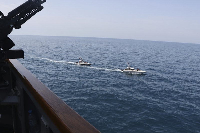 In this Wednesday, April 15, 2020, photo made available by U.S. Navy, Iranian Revolutionary Guard vessels sail close to U.S. military ships in the Persian Gulf near Kuwait. A group of 11 Iranian naval vessels made "dangerous and harassing" maneuvers near U.S. ships in the Persian Gulf near Kuwait on April 15, in one case passing within 10 yards of a U.S. Coast Guard cutter, U.S. officials said. Iranian officials did not immediately acknowledge the incident. (U.S. Navy via AP)
