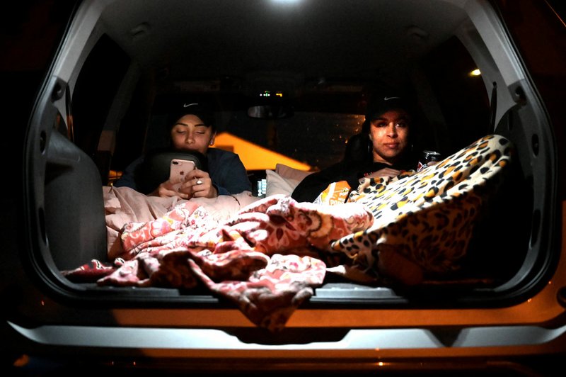 Ciara Pelts (left) and Jackie Lewis watch A Beautiful Day in the Neighborhood during Fort Smith Brewing Company's first drive-in movie night on Thursday. (Arkansas Democrat-Gazette/Stephen Swofford)