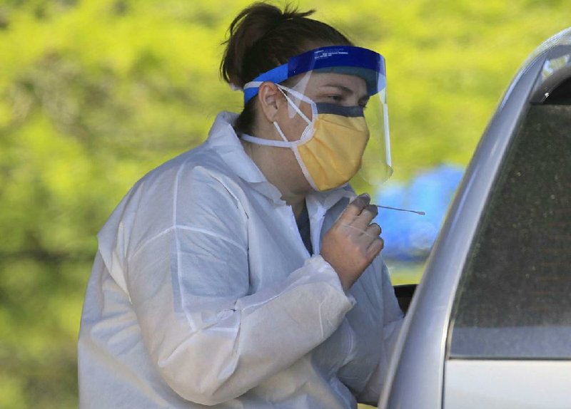 Nurse Tonya Green talks with a patient Monday at Arkansas Surgical Hospital’s drive-thru covid-19 testing site at the New Life Church in North Little Rock.
(Arkansas Democrat-Gazette/Staton Breidenthal)