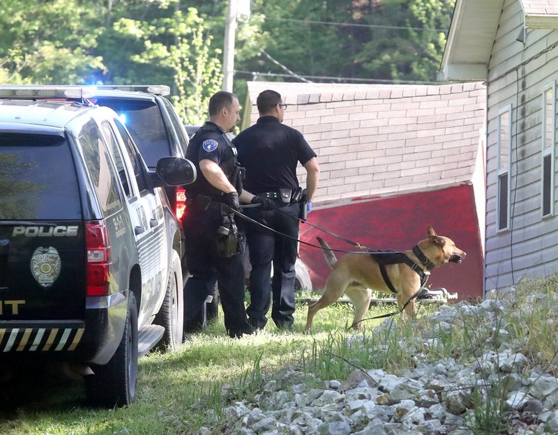 Hot Springs Police K-9 Officer Brandon Jones, left, and his dog, Nitro, track a suspect, later identified as Joshua Edward Gross, 35, near the intersection of Woodfin and Sabie streets. Gross allegedly fled on foot after wrecking his car following a vehicle pursuit by police. - Photo by Richard Rasmussen of The Sentinel-Record