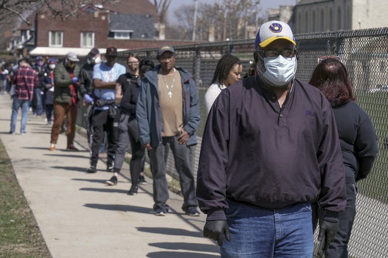 Voters observe social distancing guidelines as they wait in line to cast ballots at Washington High School while ignoring a stay-at-home order over the coronavirus threat to vote in the state's presidential primary election, Tuesday, April 7, 2020, in Milwaukee. (AP Photo/Morry Gash)