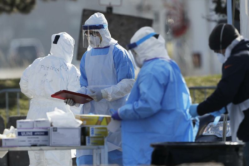 Medical personnel work at a covid-19 drive-thru testing site late last month in the parking lot of Walmart store in North Lake, Ill.
(AP/Nam Y. Huh)
