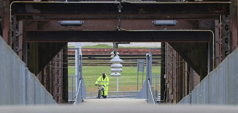 A man pushes a bicycle onto the Clinton Presidential Park Bridge in North Little Rock on Wednesday, April 22, 2020 in North Little Rock.