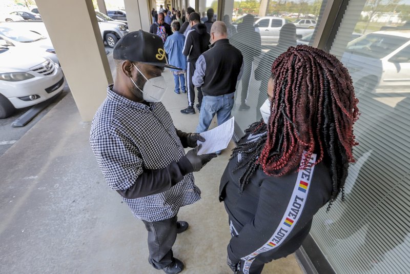 Keith Davis and his friend Jaki Hart wait in line outside the Arkansas Workforce Center at 5401 S. University Ave. in Little Rock in this April 17, 2020, file photo. They said they were filing for unemployment because of coronavirus-related layoffs.