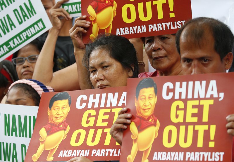 FILE - In this Nov. 21, 2018, file photo, demonstrators rally outside the Chinese Consulate to protest the two-day state visit in the country of President Xi Jinping in Manila, Philippines. The Philippines on Wednesday, April 22, 2020, has protested China's declaration of a Manila-claimed South China Sea area as part of Chinese territory and the aiming of a weapon on a Philippine navy ship, the country's top diplomat said Wednesday. (AP Photo/Bullit Marquez, File)