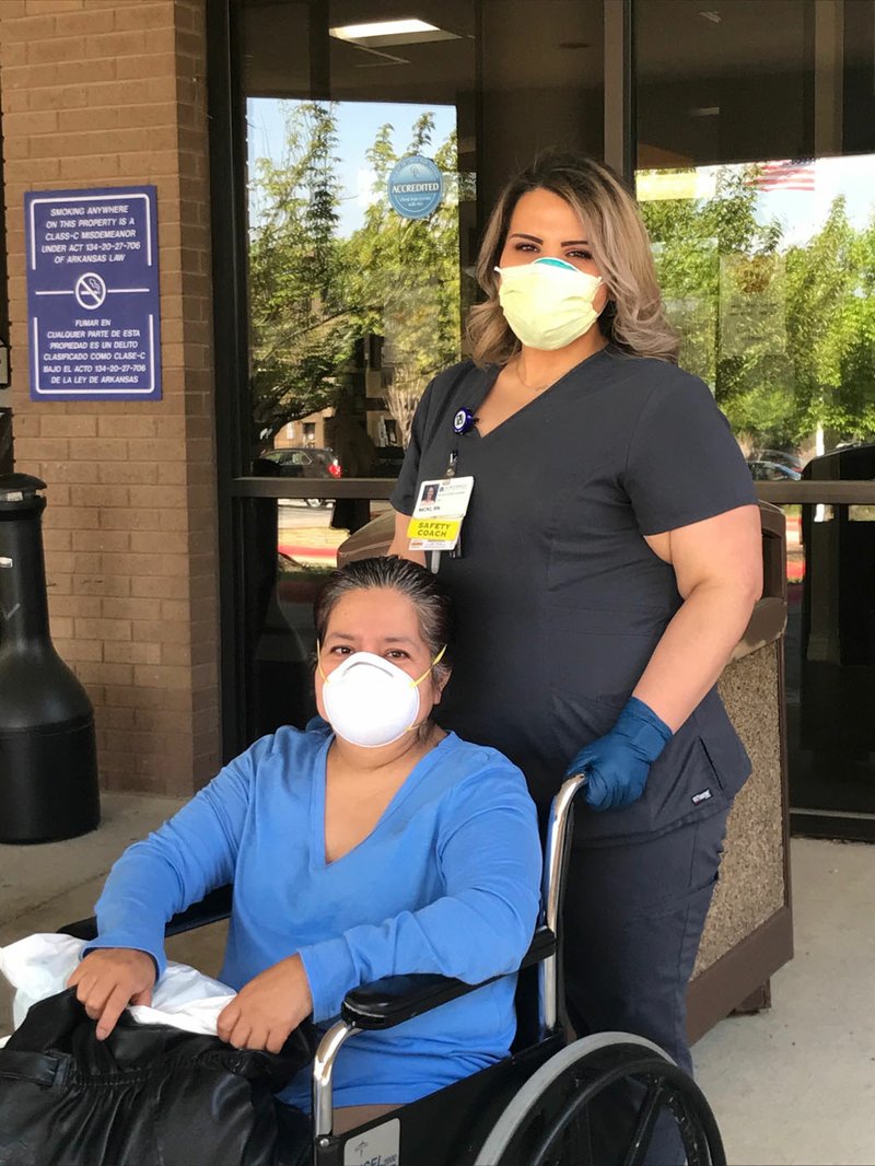 Nurse Nicki Troutner (right) pushes covid-19 patient Mirna Marquez in a wheelchair Monday outside of Northwest Medical Center in Springdale as Marquez is released from the hospital after two weeks. (Courtesy Photo/Northwest Health System)