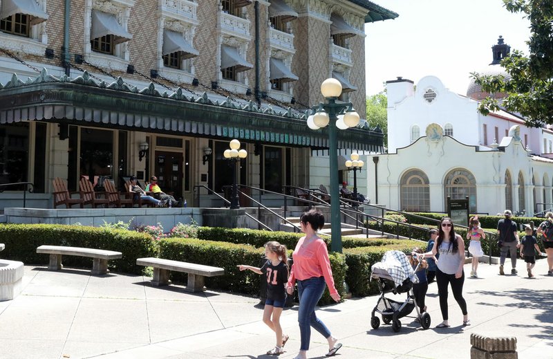 Hot Springs National Park visitors walk past the Fordyce Bath House, which was closed due to the pandemic, on Tuesday, April 21, 2020. - Photo by Richard Rasmussen of The Sentinel-Record