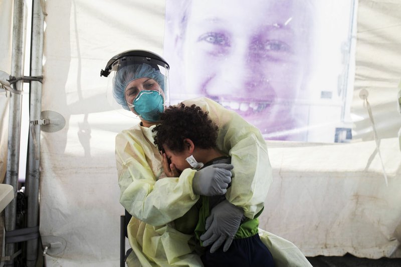 Nurse Julie Palmer consoles Luca'Brasi Means, 4, after swabbing his nose Friday to test for covid-19 at a drive-through testing site at the Mercy Convenient Care in Bentonville. Go to nwaonline.com/200425Daily/ for today's photo gallery. (NWA Democrat-Gazette/Charlie Kaijo)