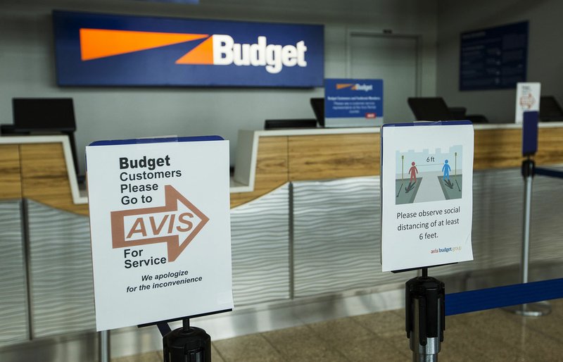 Signs regarding closings and social distancing stand Friday at the rental car area in Northwest Arkansas National Airport in Highfill. Go to nwaonline.com/photos to see more photos. (NWA Democrat-Gazette/Ben Goff)