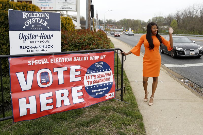 In a photo taken Tuesday, April 21, 2020, Kimberly Klacik, who is the Republican 7th Congressional District candidate, waves for a supporter hoking its horn as she poses for a photograph with The Associated Press in Timonium, Md. Democrat Kweisi Mfume and Klacik won special primaries for the Maryland congressional seat that was held by the late Elijah Cummings. (AP Photo/Julio Cortez)