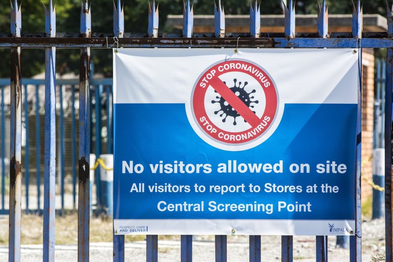 A coronavirus notice hangs at the entrance gates of the Impala Platinum Holdings mine in Rustenburg, South Africa, on April 22, 2020. (Bloomberg photo by Waldo Swiegers)