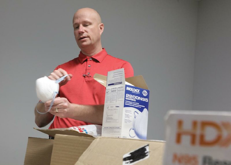 Nathan Spicer, an emergency manager specialist with the Little Rock city manager’s office, shows off personal protection equipment donated by anonymous contributors Wednesday at the city’s Emergency Operations Center on Murray Street.
(Arkansas Democrat-Gazette/John Sykes Jr.)