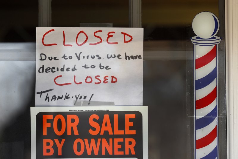 "For Sale By Owner" and "Closed Due to Virus" signs are displayed in the window of a store in Grosse Pointe Woods, Mich., in this April 2, 2020, file photo. (AP file photo)