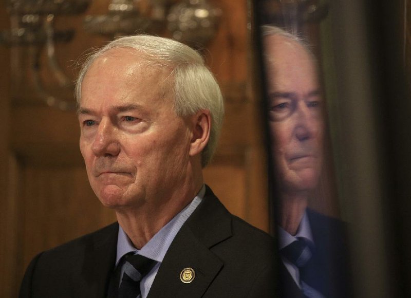 Gov. Asa Hutchinson listens to Health Secretary Dr. Nate Smith answer a question from the media Monday April 27, 2020 at the state Capitol in Little Rock during the daily coronavirus briefing. (Arkansas Democrat-Gazette/Staton Breidenthal)