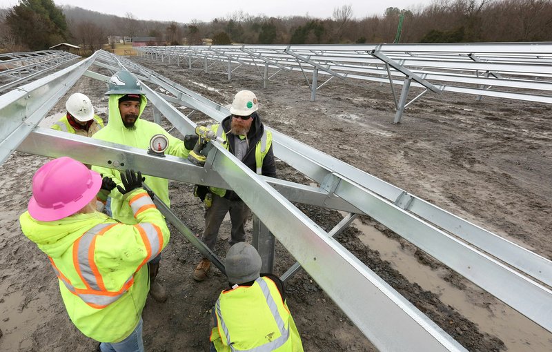 Shawn Kelly (center), with Dixie Construction, works with personnel to secure a knee brace Thursday, January 30, 2020, on ground mounts for solar panels at the Washington County South Campus in Fayetteville. Lightwave Solar is installing 3,162 405 watt solar panels for the county on the ground, 273 panels on the Bridge Building and 1,022 panels on the Roads Building. Check out nwadg.com/photos for today's photo gallery.
(NWA Democrat-Gazette/David Gottschalk)