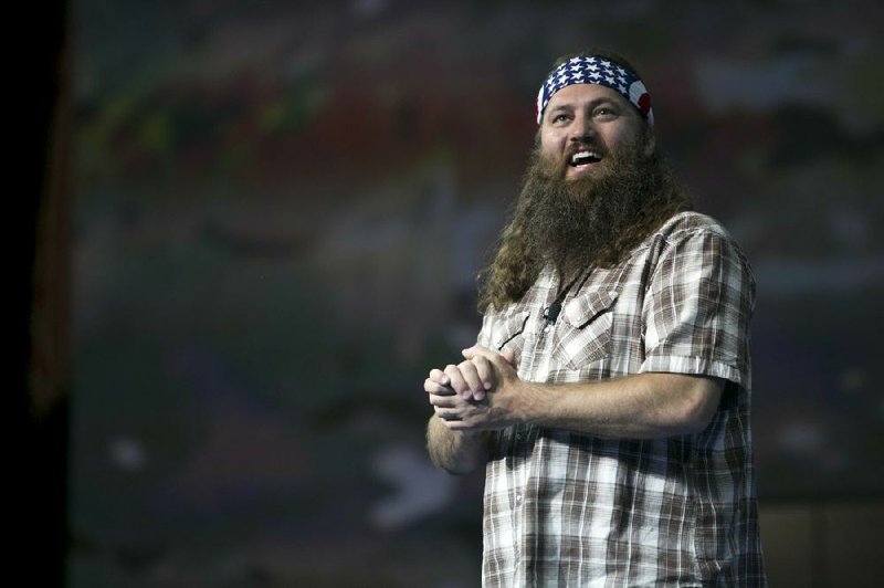 FILE - Duck Commander CEO and star of the reality television series Duck Dynasty, Willie Robertson speaks to the 6,000 domestic Walmart shareholders at Bud Walton Arena in Fayetteville, Ark., Wednesday, June 5, 2013. Mehgan Cook and Charlie Miller had a camouflage theme as they tied the knot at the new Field & Stream store in Butler County on Saturday morning, Aug. 17, 2013. The two hadn’t planned on marrying at the Cranberry Township store, but Cook said they were eager to meet “Duck Dynasty” star Willie Robertson. “I was going to cancel the wedding ‘cause I head Willie was coming,” she said. Instead, Cook said, her mother came up with the idea of a wedding at the store - and they got a surprise when Robertson appeared during the ceremony. (AP Photo/Gareth Patterson)