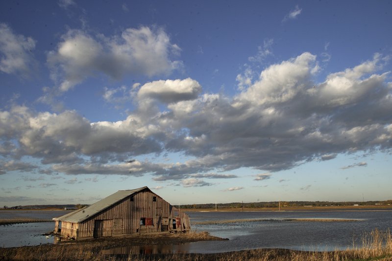 FILE- In this Oct. 22, 2019 photo, a barn sits in floodwaters in Pacific Junction, Iowa. The floodplain awaiting this year's surge is part of a changing picture, altered from just a few decades ago. It is now dotted with more parks, marshes and forests on land surrendered in recent years by communities and individuals. (AP Photo/Nati Harnik, File)