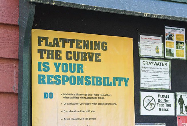 A sign at Lake Catherine State Park reminds visitors to practice social distancing. - Photo by Grace Brown of The Sentinel-Record