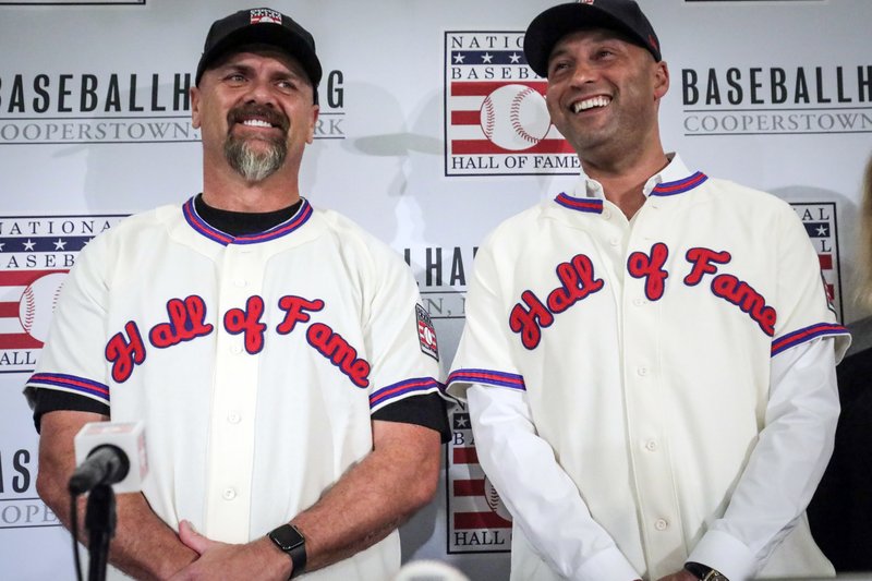 FILE - In this Jan. 22, 2020, file photo, former New York Yankees shortstop Derek Jeter, right, and former Colorado Rockies outfielder Larry Walker pose after receiving their Baseball Hall of Fame jerseys during a baseball news conference in New York. Jeter and Walker and the rest of this year's Baseball Hall of Fame class will have to wait for their big moment at Cooperstown. The Hall of Fame announced Wednesday, April 29, 2020, that it has canceled its July 26 induction ceremony because of the coronavirus outbreak. (AP Photo/Bebeto Matthews, File)