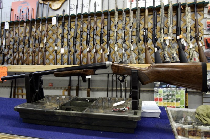 FILE - In a May 16, 2006 file photo, rifles line a hunting store's shelves in Ottawa. Prime Minister Justin Trudeau said Friday, May 1, 2020 that Canada is banning the use and trade of assault-style weapons immediately. (Jonathan Hayward/The Canadian Press via AP)