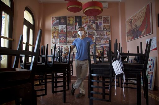 Gregory Biniowsy, a Canadian citizen who is co-founder of the Nazdarovie restaurant, poses for a photo at his restaurant, closed amid the lockdown to help contain the spread of the new coronavirus in Havana, Cuba, Thursday, April 23, 2020. Many restaurants are closed while only work considered essential is allowed to continue. (AP Photo/Ismael Francisco)
