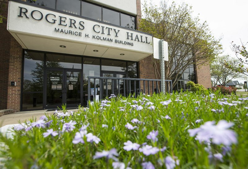 Flowers bloom Friday at the entrance to Rogers City Hall. Containers outside provide a place for people to donate face masks and drop off paperwork while city hall is closed. Go to nwaonline.com/photos to see more photos. (NWA Democrat-Gazette/Ben Goff)