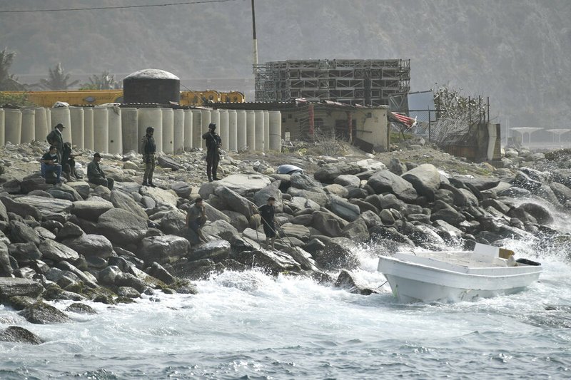 Security forces guard the shore area and a boat in which authorities claim a group of armed men landed in the port city of La Guaira, Venezuela, on Sunday, May 3, 2020. Interior Minister Nestor Reverol said on state television that security forces overcame an armed maritime incursion before dawn Sunday. He said the Venezuelans stopped speedboats from neighboring Colombia in a conflict in which several attackers were killed and others detained.


