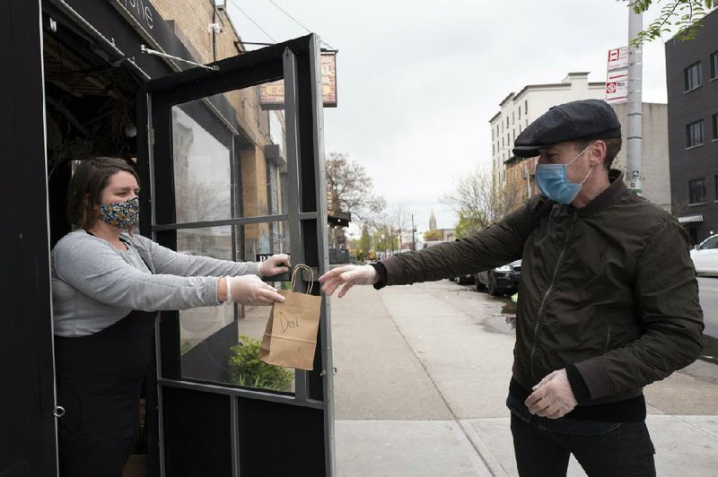 Sara Gilmore hands a do-it-yourself color kit to client Don O’Donoghue at her hair salon in New York. Like many small businesses in the grooming and beauty industry, Gilmore’s Sara June salon is doing everything it can to survive.
(AP/Mark Lennihan)