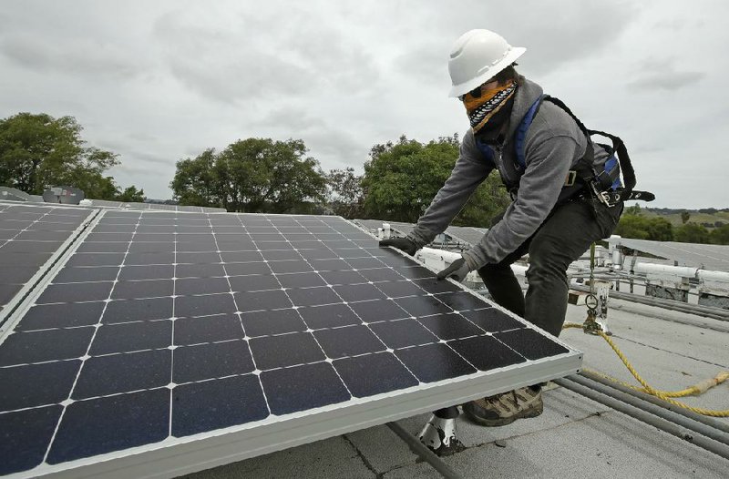 Gen Nashimoto installs solar panels last week in Hayward, Calif. More photos at arkansasonline.com/53renewable/.
(AP/Ben Margot)