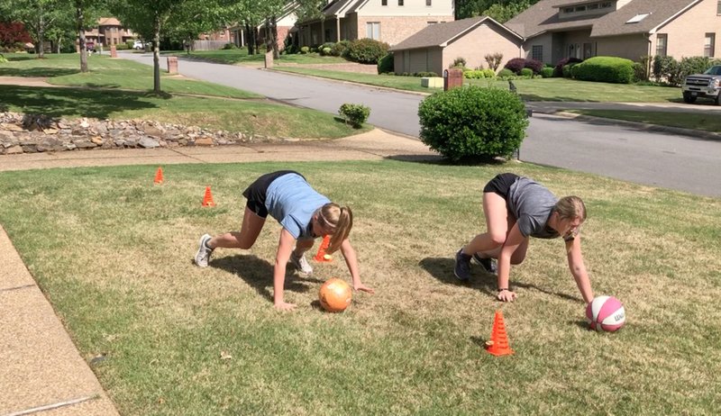 Sixteen-year-old Meredith Pinkston (left) and her 21-year-old sister, Maggie, compete in the Ball Race on April 29. (Arkansas Democrat-Gazette/Celia Storey)