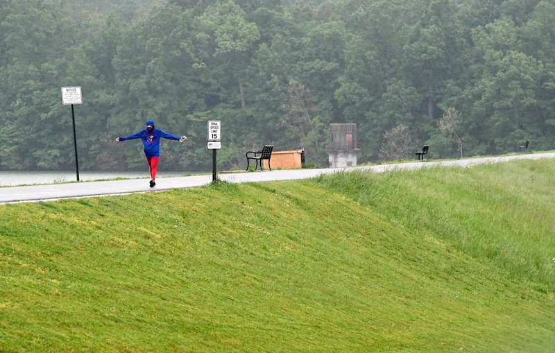 A pedestrian walks Monday along the trail across the Lake Fayetteville dam. The city is planning a redesign of the trail and is applying for a grant from the state Department of Transportation. Go to nwaonline.com/2005045Daily/ for more images. (NWA Democrat-Gazette/J.T. Wampler)